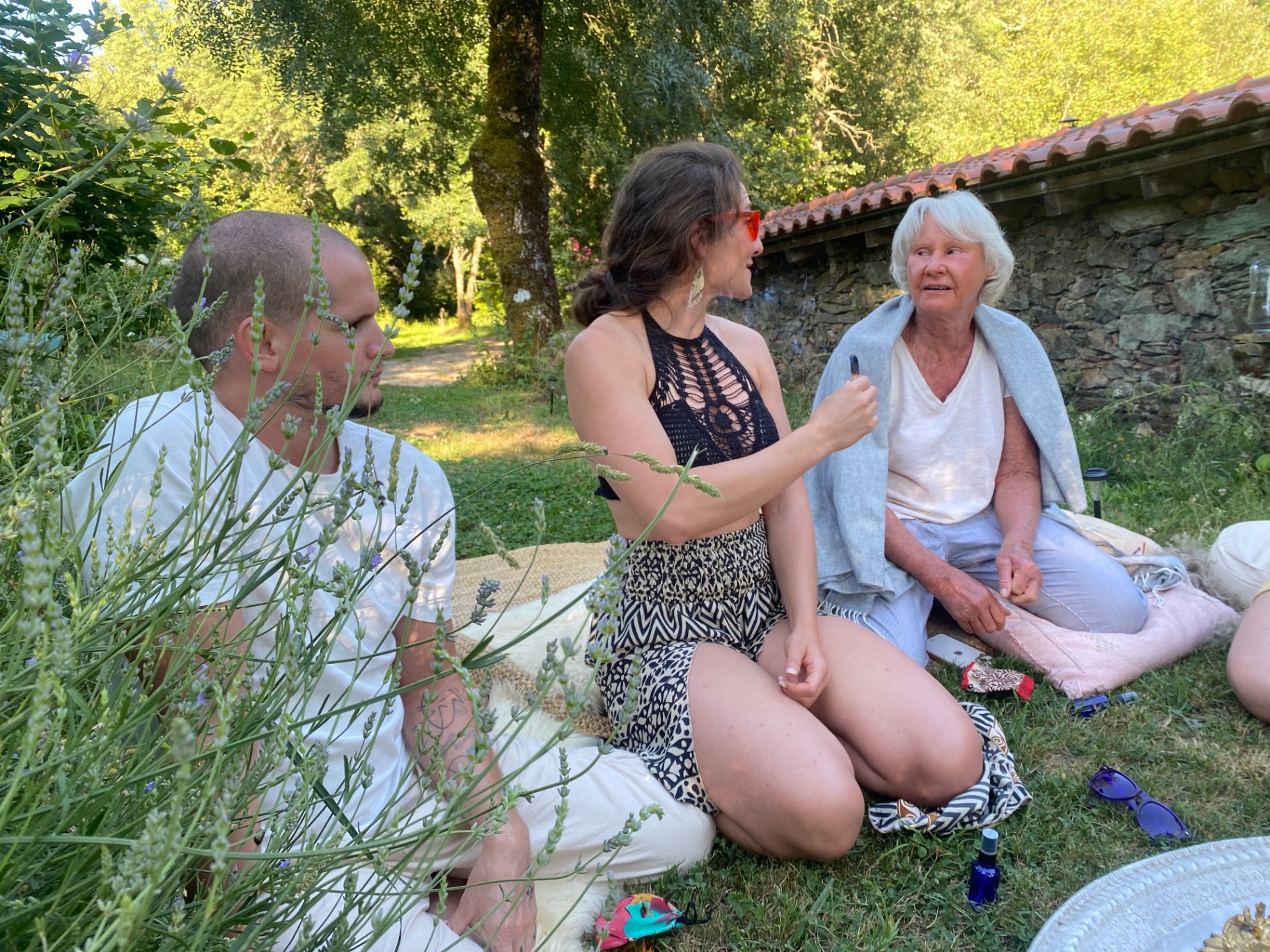 Three people sitting in a circle among the lavender