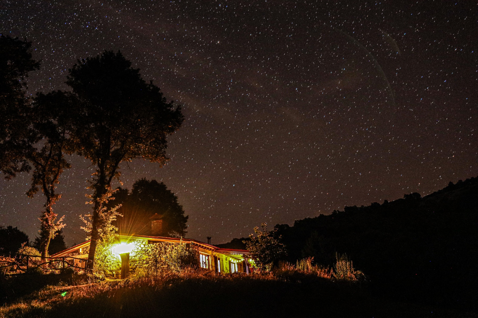 Montestal farmhouse glowing warmly under a vast starlit sky